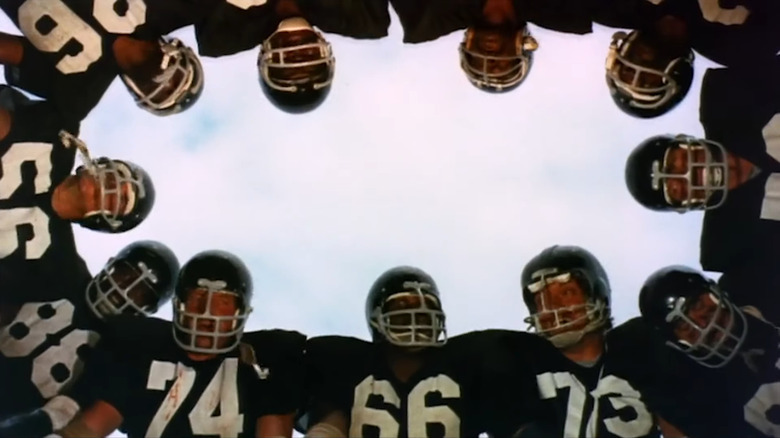 The prison football team in a huddle in The Longest Yard