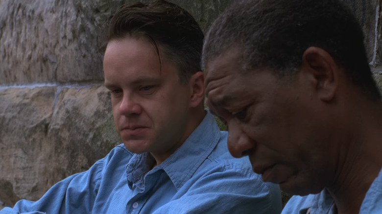 Andy (Tim Robbins) and Red (Morgan Freeman) sitting against wall in The Shawshank Redemption