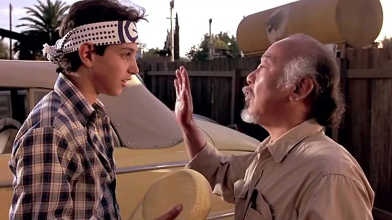 Ralph Macchio and Pat Morita as Daniel LaRusso and Mr. Miyagi before waxing the car in The Karate Kid