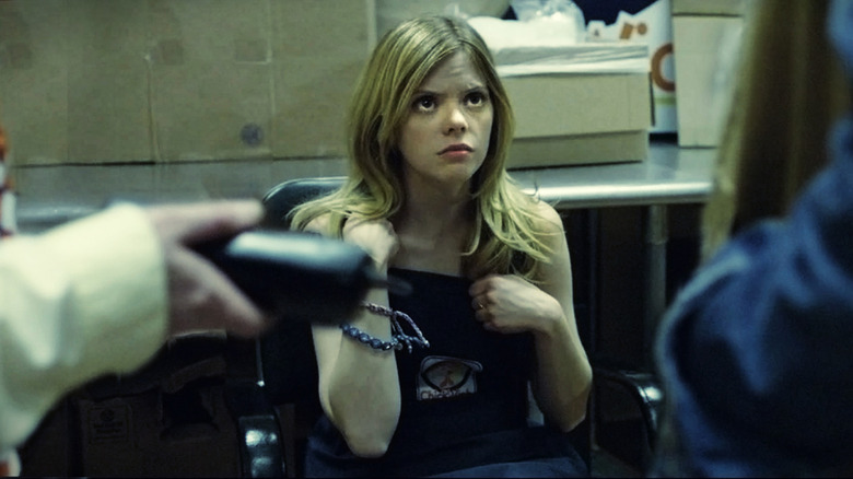 Becky (Dreama Walker) is offered a phone under duress in Compliance