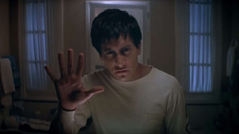 Donnie Darko (Jake Gyllenhaal) puts his hand to the mirror in Donnie Darko