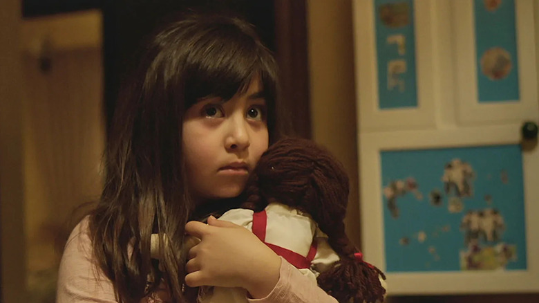 Dorsa (Avin Manshadi) holds her doll with fright in Under the Shadow