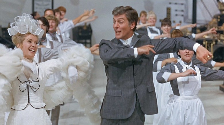 Caractacus Potts (Dick Van Dyke) dances with Truly Scrumptious (Sally Ann Howes) and a chorus of maids in Chitty Chitty Bang Bang
