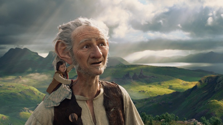 Sophie (Ruby Barnhill) rides on the shoulder of the BFG (Mark Rylance) as he glances in wonder at the clouds in The BFG (2016)