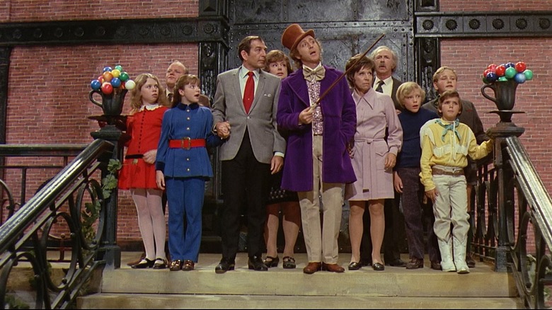 Willy Wonka (Gene Wilder) leads children and their parents into his factory while pointing his cane in Willy Wonka & the Chocolate Factory