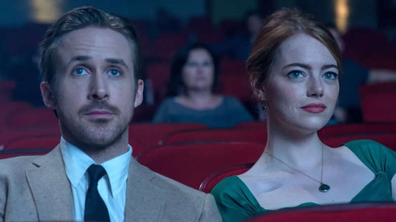 Ryan Gosling and Emma Stone as Sebastian and Mia, sitting in a movie theater in La La Land