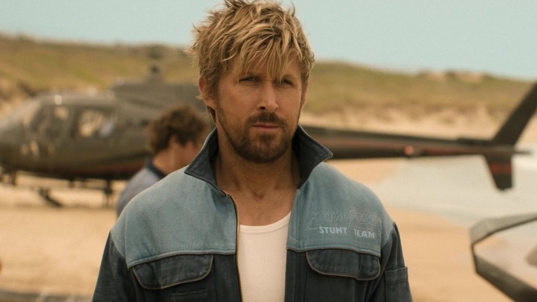 Ryan Gosling as Colt, standing in front of a helicopter in The Fall Guy