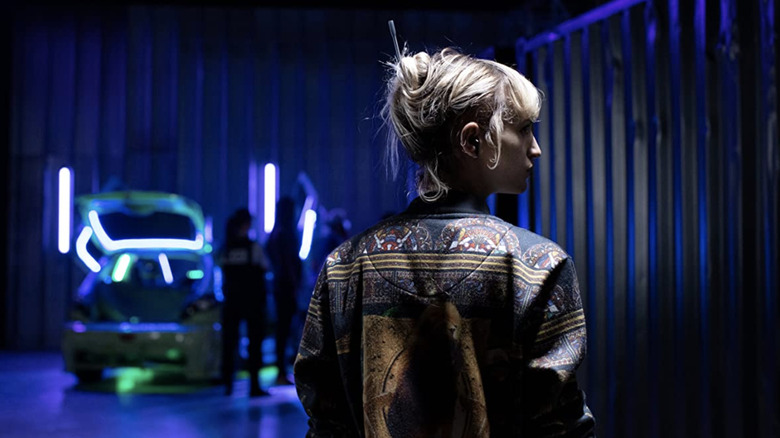 Alexia walking in a neon-lit alley