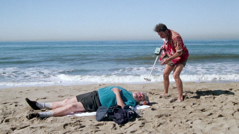 Kramer (Michael Richards) scans a man with a metal detector in Seinfeld