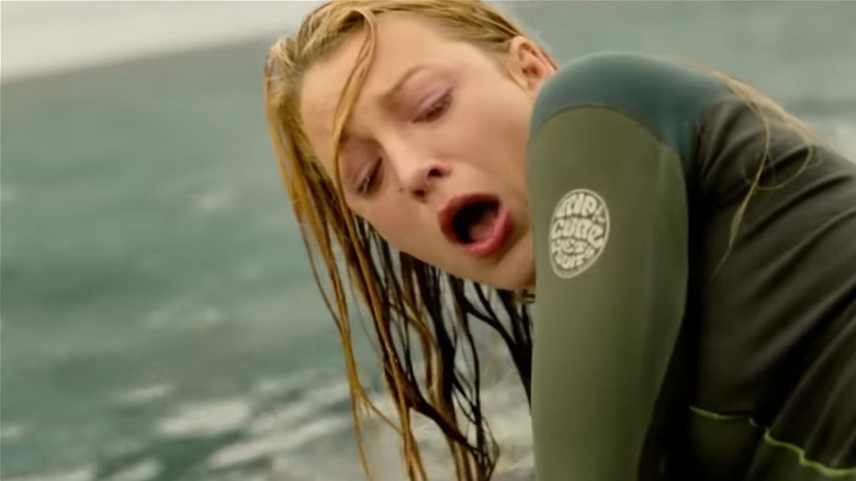 A horrified Blake Lively as Nancy in The Shallows looks at her bloody leg