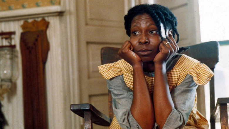 Celie sits in chair with head in hands