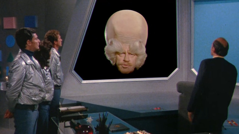 The crew listen to The Head (Alan Caillou) on Quark
