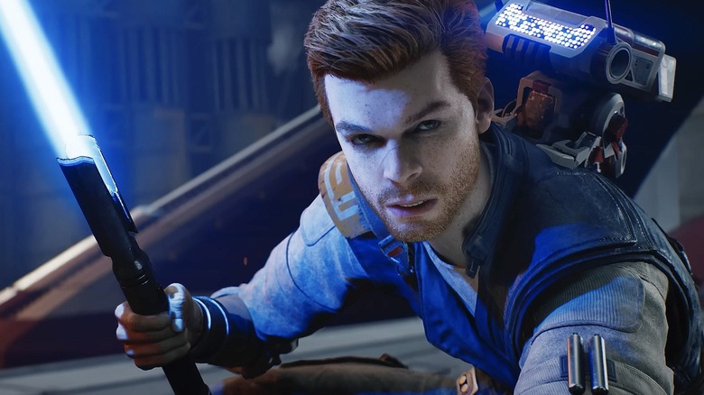 Cal Kestis (Cameron Monaghan) crouches while igniting his lightsaber in Star Wars Jedi: Survivor
