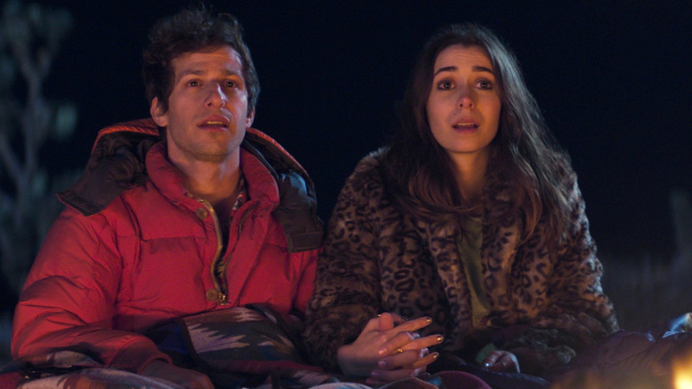 Andy Samberg and Cristin Milioti as Nyles and Sarah by a campfire in Palm Springs