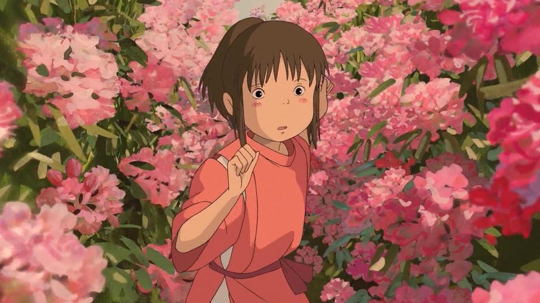 Chihiro surrounded by pink flowers in Spirited Away