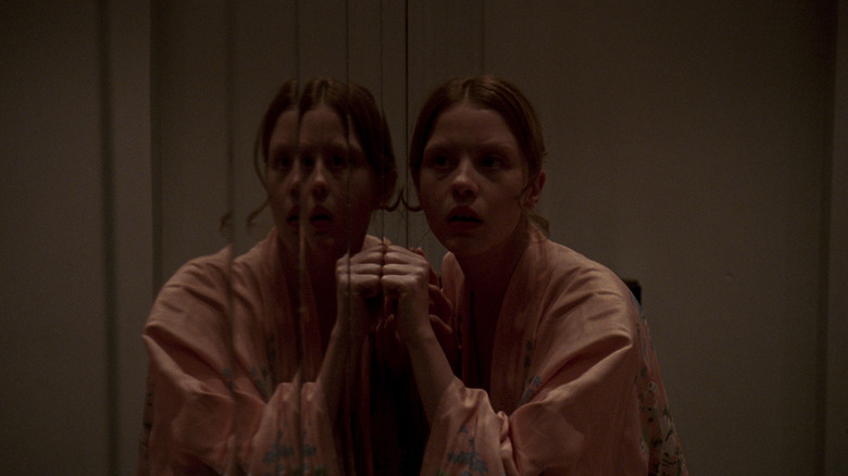 Girl listens to mirror in Suspiria