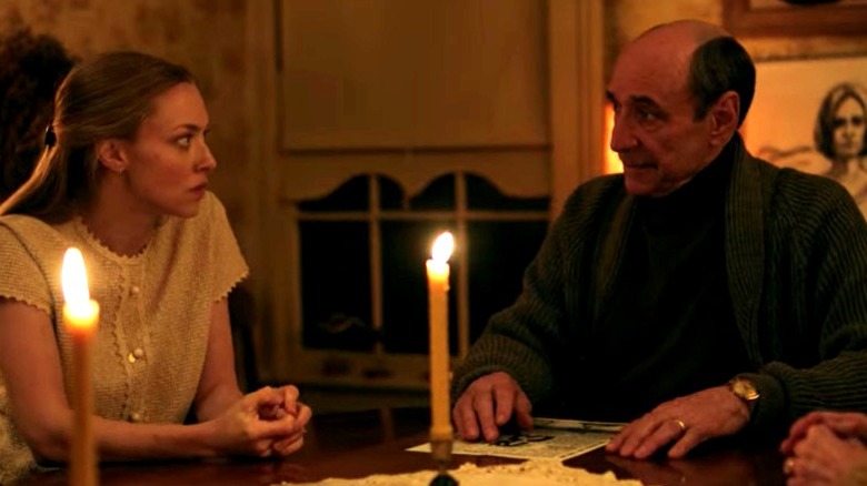 Amanda Seyfried and F. Murray Abraham sit at candlelit table