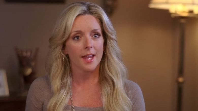 Jane Krakowski as Jenna Maroney sitting at a desk and talking on 30 Rock