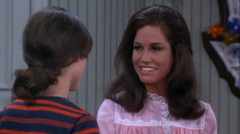 Mary Richards (Mary Tyler Moore) smiles and listens on The Mary Tyler Moore Show