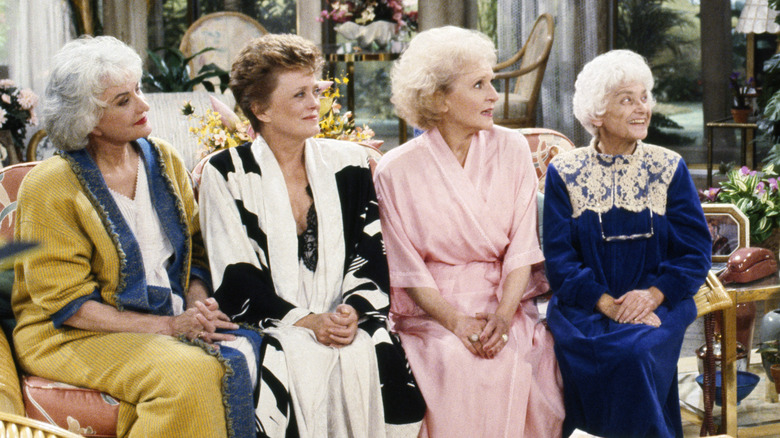 Bea Arthur's Dorothy. Rue McClanahan's Blanche, Betty White's Rose, and Estelle Getty's Sophia sitting on a couch in The Golden Girls