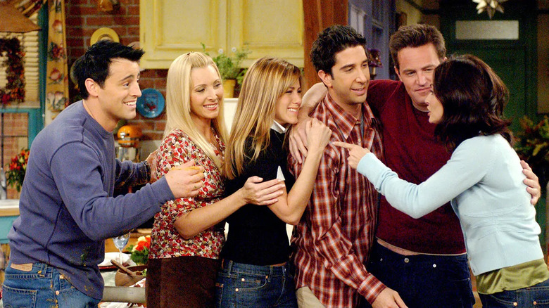 Matt LeBlanc, Lisa Kudrow, Jennifer Aniston, David Schwimmer, Matthew Perry, and Courtney Cox as Joey, Phoebe, Rachel, Ross, Chandler, and Monica embrace in an episode of Friends.