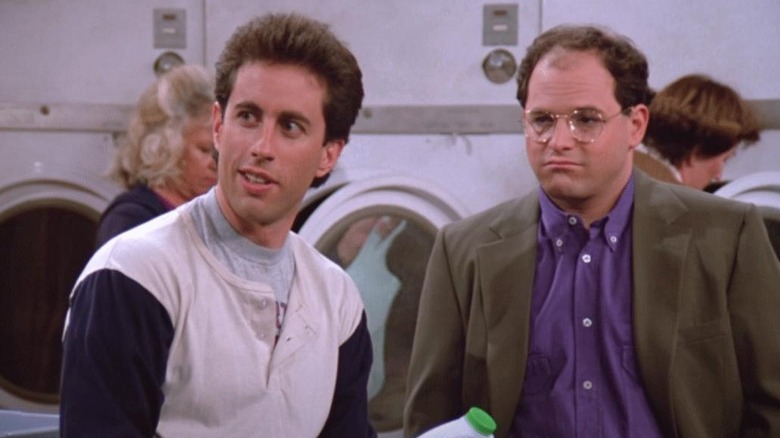 Jerry Seinfeld as Jerry Seinfeld and Jason Alexander as George Costanza in a laundromat in Seinfeld.