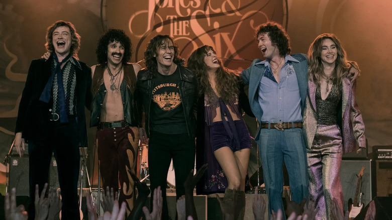 Will Harrison as Graham, Sebastian Chacon as Warren, Sam Claflin as Billy, Riley Keough as Daisy, Josh Whitehouse as Eddie, and Suki Waterhouse as Karen on-stage in Daisy Jones & the Six