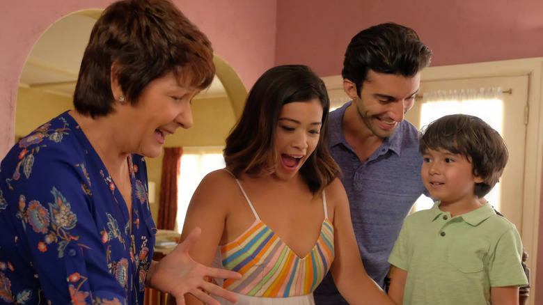 Gina Rodriquez as Jane Villanueva looks at her first book with family in Jane the Virgin.
