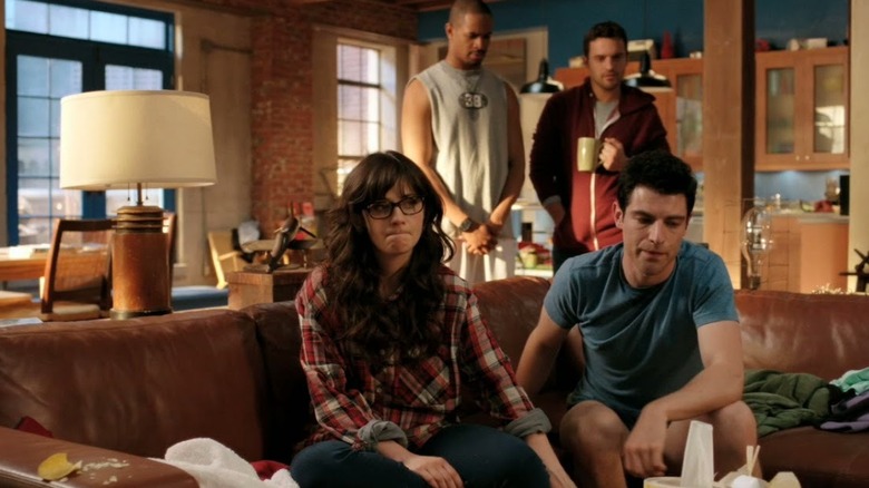 Zooey Deschanel as Jess Day sits next to Jake Johnson as Nick Miller in New Girl.