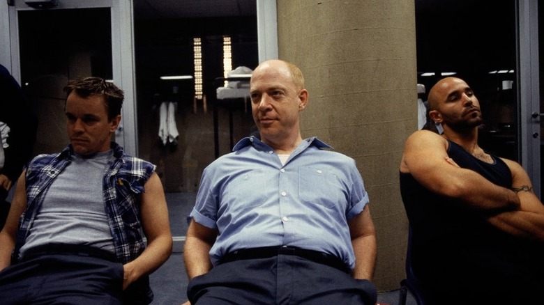 J.K. Simmons as Vernon Schillinger sits amused next to inmates in Oz.