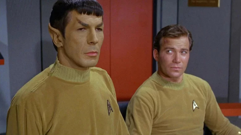 William Shatner as Kirk glances curiously at Leonard Nimoy as Spock in Star Trek: The Original Series.