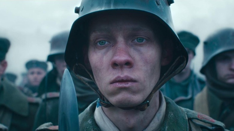 Felix Kammerer as Paul Bäumer lined up with other soldiers with a jaded expression in All Quiet on the Western Front