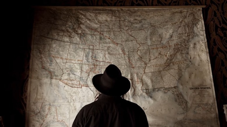 Neil Young standing in front of a large map of the United States in Paradox