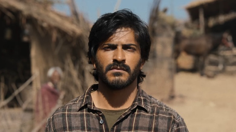 Harshvardhan Kapoor standing in front of a wood house in Thar