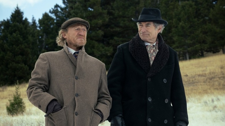 Banner Creighton (Jerome Flynn) and Donald Whitfield (Timothy Dalton) stand together by a forest in 1923