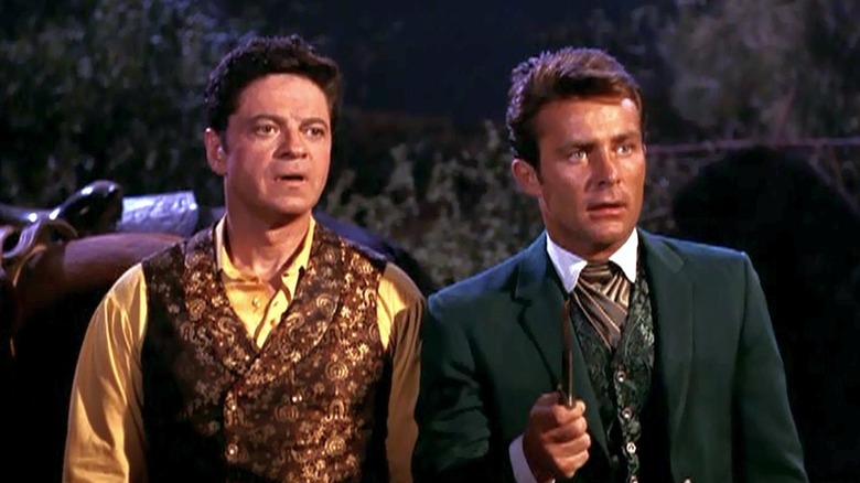 Artemus Gordon (Ross Martin) stands surprised next to James West (Robert Conrad) by their horses in The Wild Wild West