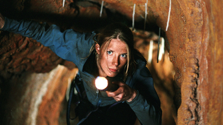 Woman in cave with flashlight