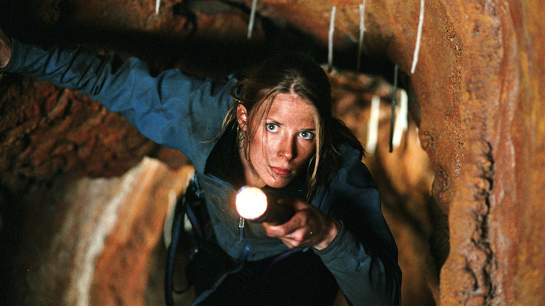 Woman in cave with flashlight