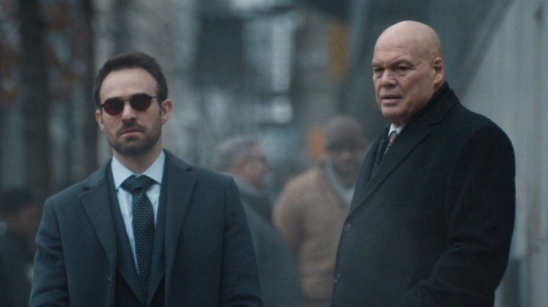 Charlie Cox as Matt Murdock walks outside while Vincent D'Onofrio as Wilson Fisk stands behind him on Daredevil: Born Again