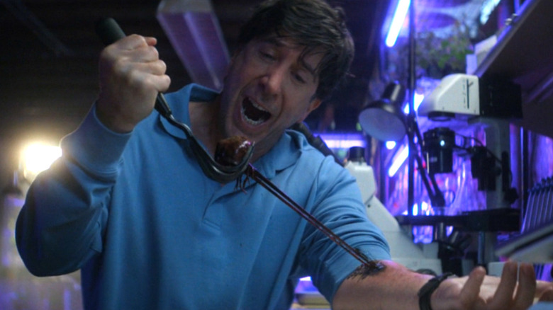 David Schwimmer as Anthony Brewer pulls a paranormal being out of his arm in Goosebumps: The Vanishing