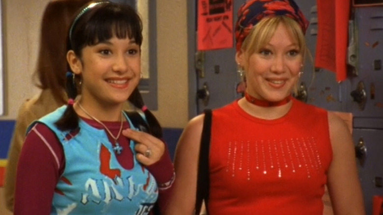 Lalaine as Miranda stands next to Hilary Duff as Lizzie McGuire in a school hallway in Lizzie McGuire
