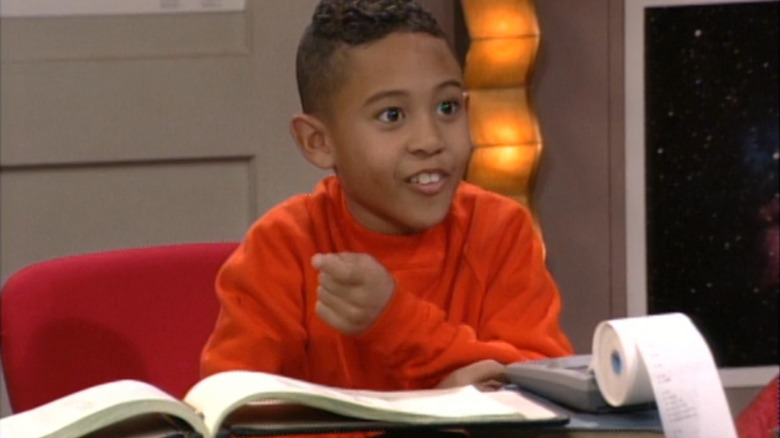 Tahj Mowry as T.J. sits in front of a book and a calculator in Smart Guy