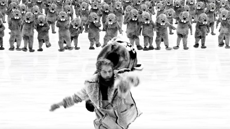 Ryland Tews as Jean Kayak being chased by a crowd of actors in beaver costumes in the poster for Hundreds of Beavers