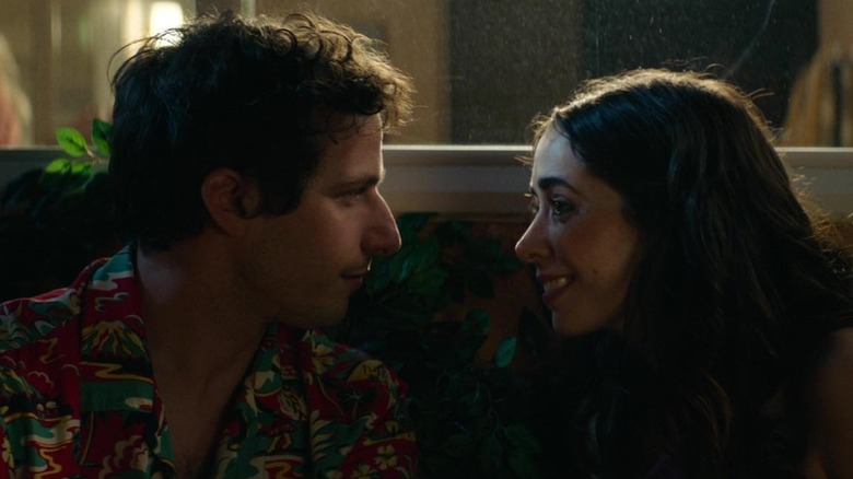 Andy Samberg and Cristin Milioti as Niles and Sarah sitting by a window leaning in for a kiss in Palm Springs