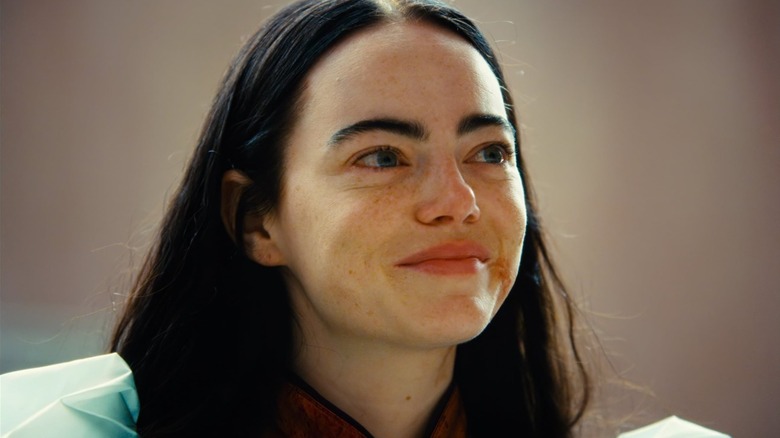 Emma Stone as Bella Baxter smiling in color in Poor Things