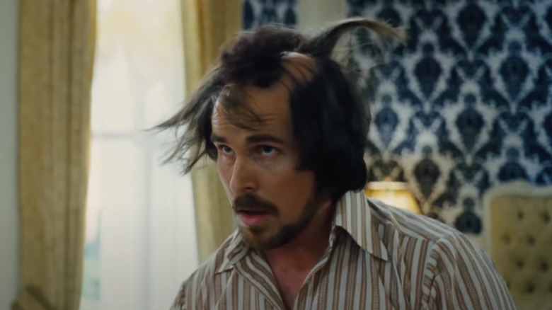 Irving Rosenfeld fixes his hair
