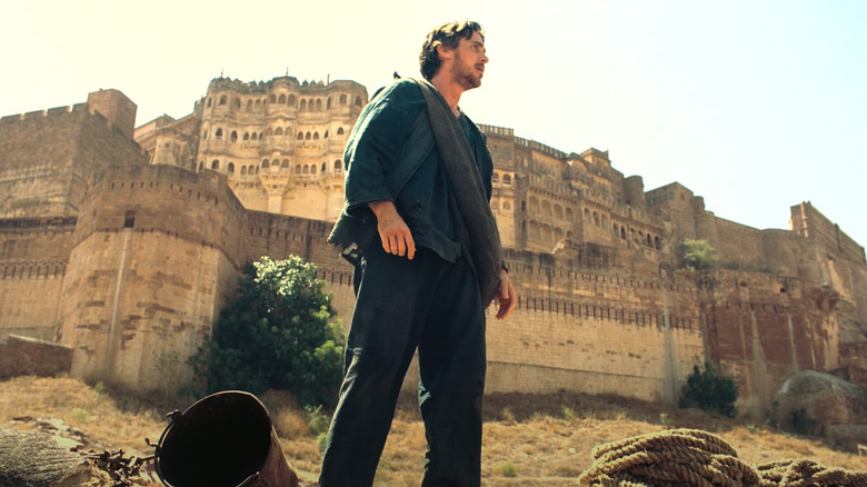 Bruce Wayne stands above the pit