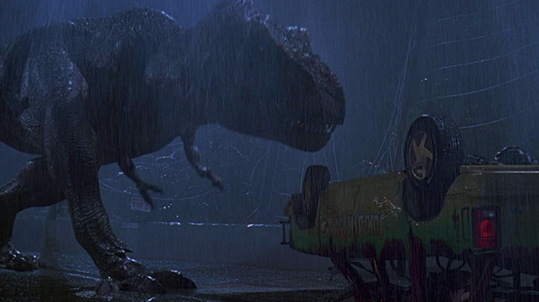 A T-Rex approaching an upside-down car
