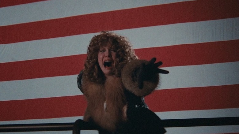 Sally Bedina (Nancy Allen) screams in front of an American flag backdrop in Blow Out