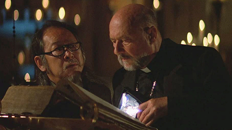 Howard Birack (Victor Wong) and the priest (Donald Pleasence) read an ancient text in Prince of Darkness